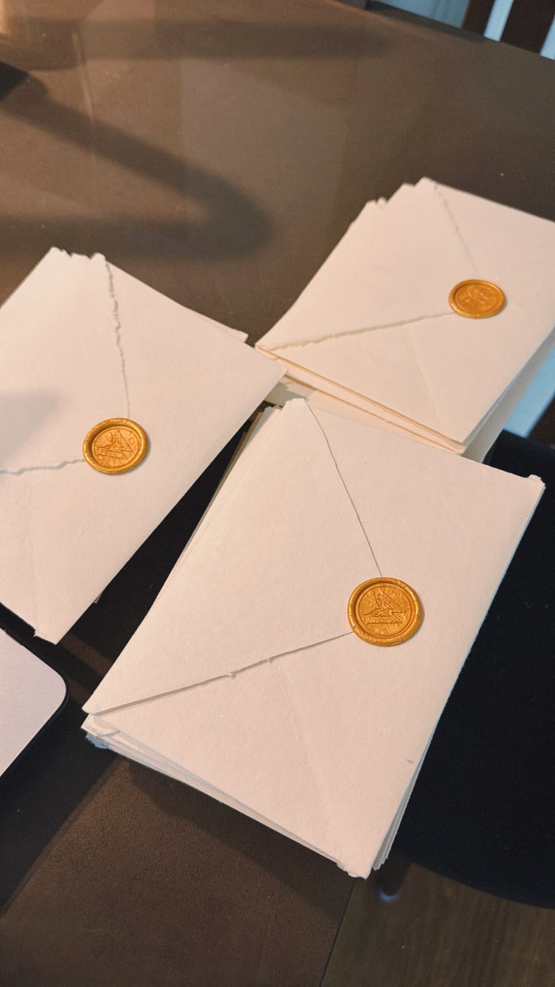 Handmade envelopes closed with gold wax seals for the guests