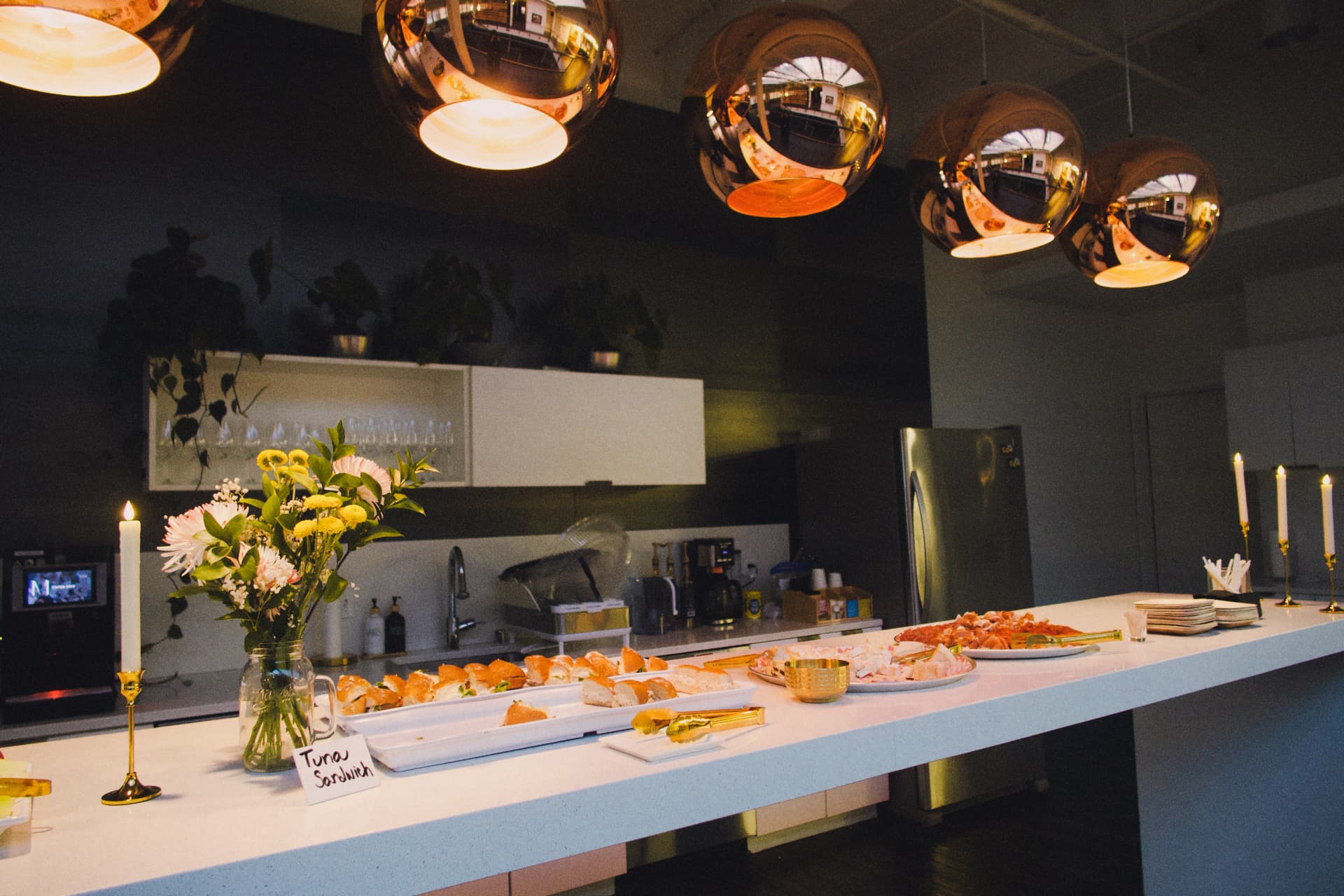 The food and drink spread laid out under copper pendant lights